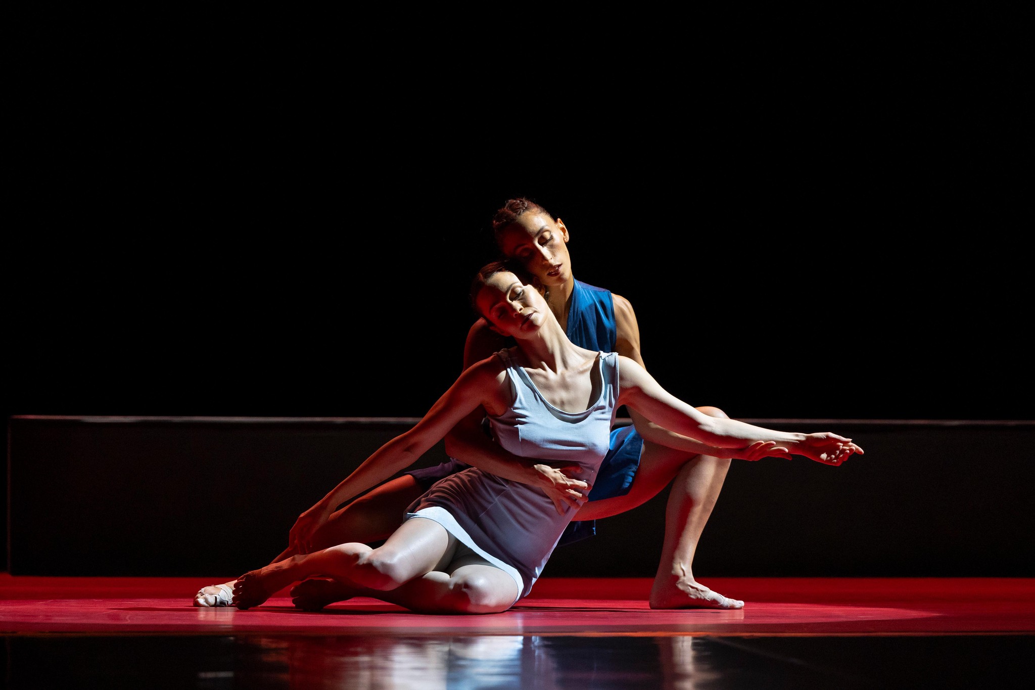 Tänzerinnen Mirea Delogu und Verity Jacobsen treten im Stück ’Annonciation’ von Angelin Preljocaj beim Festival Montpellier Danse am 19. Juni 2023 auf. Sie sind in einer eindrucksvollen Pose auf einer rot beleuchteten Bühne im Opéra Berlioz, Montpellier zu sehen.