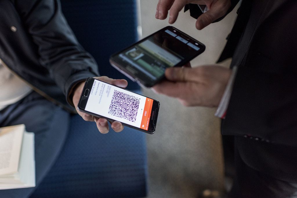 [Editor's Note: name of the passenger digitally edited] A train conductor of the Swiss Federal Railways checks passenger's tickets on a train travelling from Zurich to Lucerne, on March 20, 2017. (KEYSTONE/Christian Beutler)