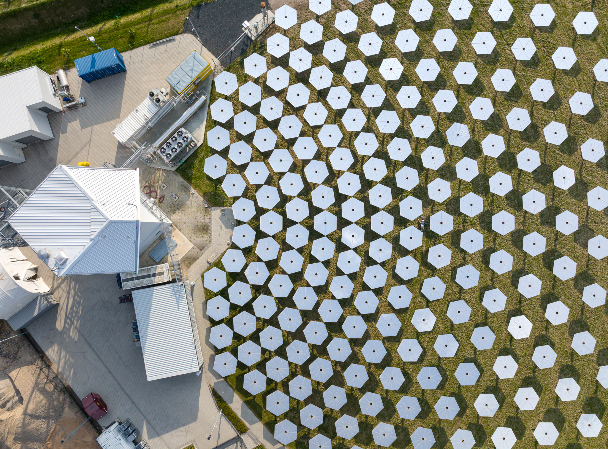 Luftaufnahme der industriellen Solarbrennstoffanlage DAWN von Synhelion, mit vielen hexagonalen Spiegeln und Gebäuden.