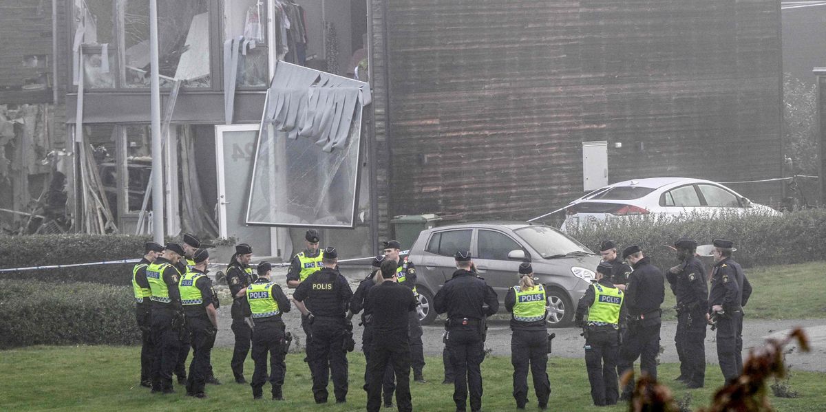 TOPSHOT - Policemen stand in front of a damaged building after a powerful explosion occurred in the early morning of September 28, 2023 in a housing area in Storvreta outside Uppsala, Sweden. A 25-year-old woman died in the blast. (Photo by Anders WIKLUND / TT NEWS AGENCY / AFP) / Sweden OUT