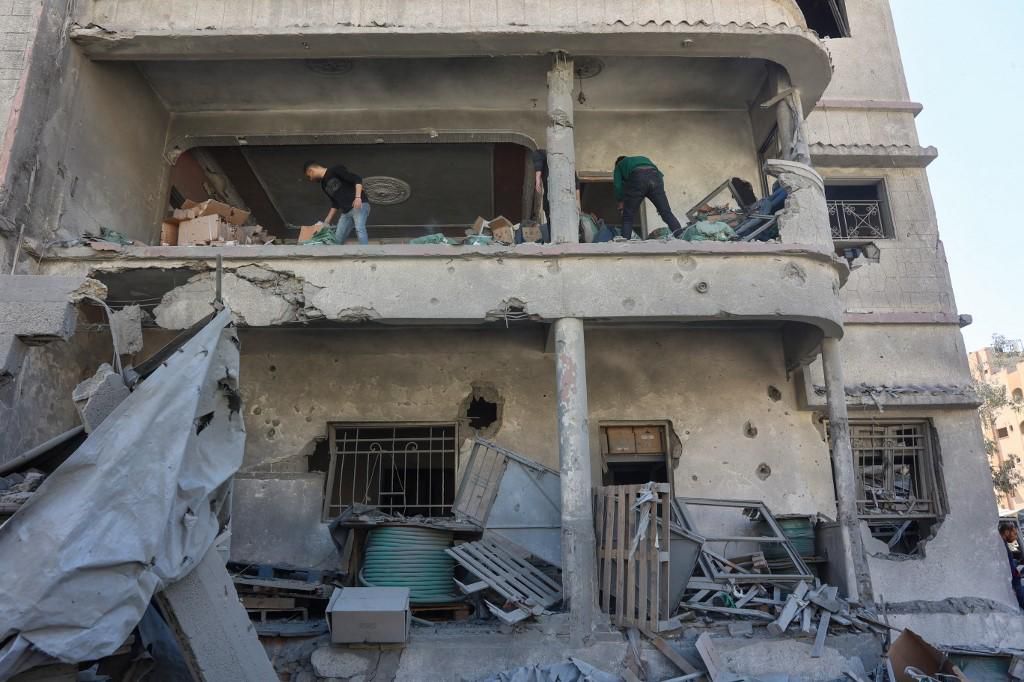 Des Palestiniens dégagent les débris d’un bâtiment endommagé près de la maison de la famille Elias Tarazi, détruite lors d’une frappe israélienne dans le quartier al-Sabra à Gaza City, le 19 mars 2025.