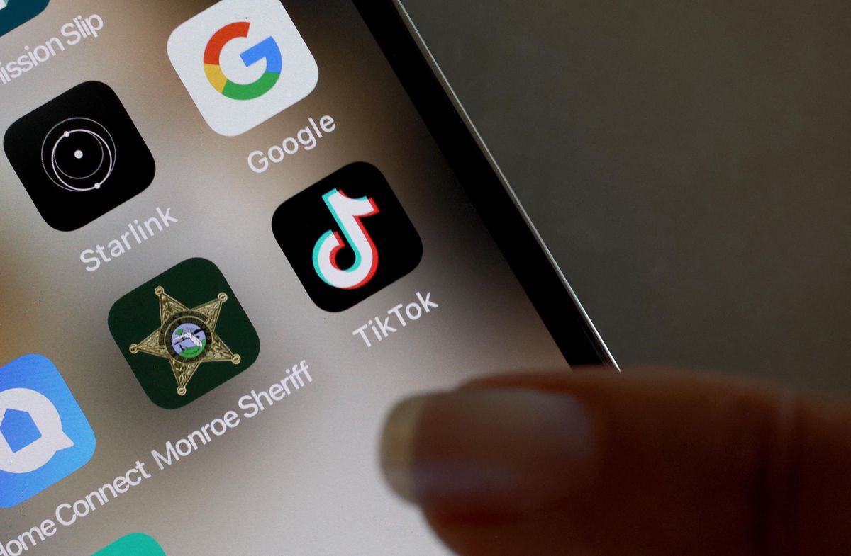 Écran d’iPhone affichant l’application TikTok, à côté d’icônes comme Google et Starlink, illustrant un contexte de débat lié à la législation en cours aux États-Unis.