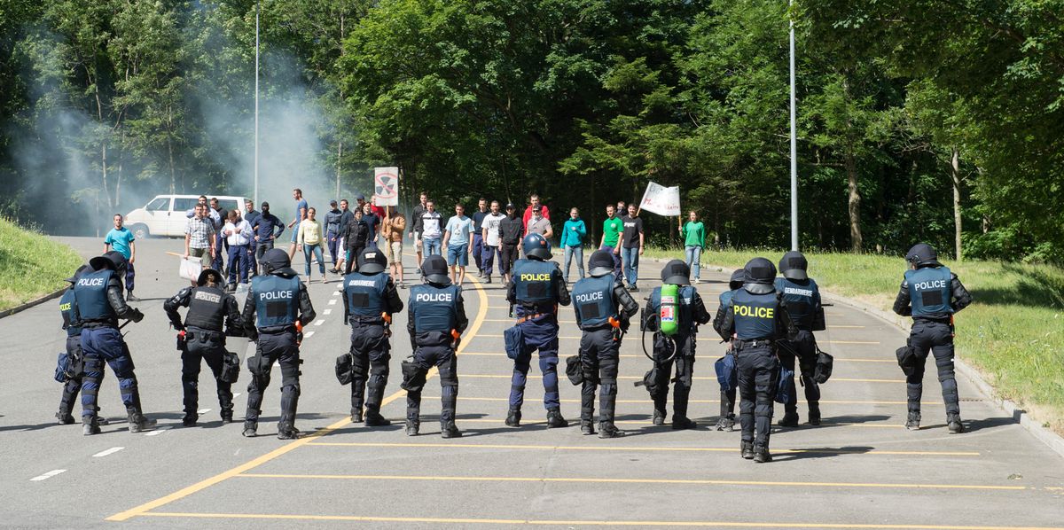 Des aspirants policiers effectuent une démonstration de contrôle de foule pour le public, avec des policiers en tenue anti-émeute face à un groupe de manifestants, lors de la journée officielle du 11e anniversaire de l'Académie de police à Savatan, le 9 juillet 2015.