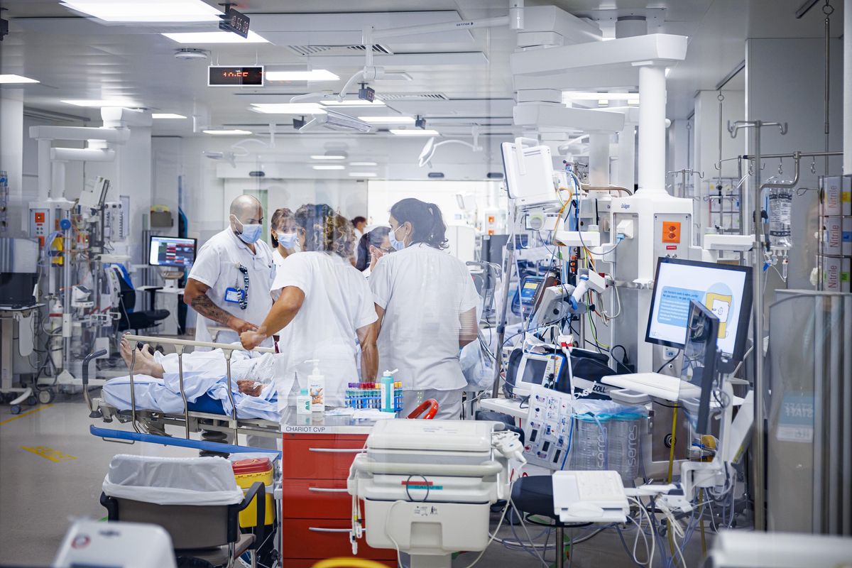 Des soignants au chevet d'un patient sous assistance respiratoire sont photographies lors d'une visite de presse en marge de l'inauguration des nouvelles urgences adultes des HUG (hopitaux universitaires de Geneve) ce mardi 3 octobre 2023 a Geneve. (KEYSTONE/Valentin Flauraud)