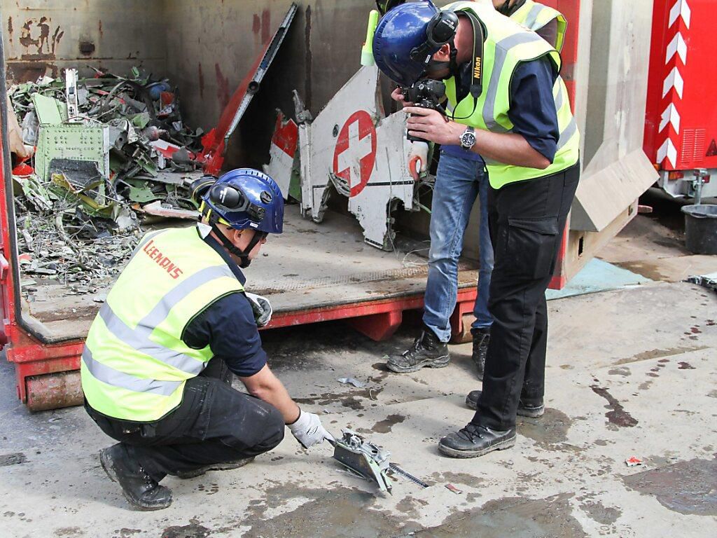 Deux enquêteurs photographient des débris du Tiger F-5 de la Patrouille suisse qui s’est écrasé le 9 juin 2016 aux Pays-Bas après une collision avec un autre avion de la formation (archives).