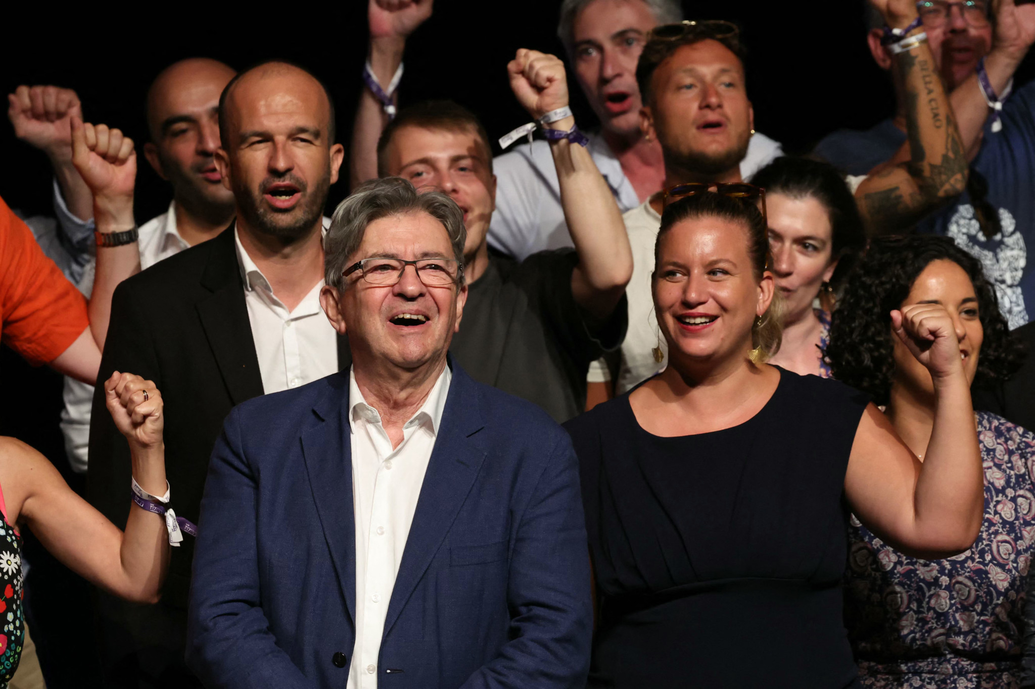 French leftist La France Insoumise (France Unbowed) LFI party's founder Jean-Luc Melenchon (C-L), and Members of Parliament and LFI members Manuel Bompard (L) and Mathilde Panot (C-R) raise their fists on the stage during the "Amfis 2024", the party's summer gathering in Chateauneuf-sur-Isere, southeastern France on August 23, 2024. (Photo by Emmanuel DUNAND / AFP)