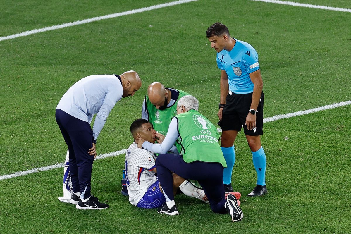 France's forward #10 Kylian Mbappe receives medical attention after a foul during the UEFA Euro 2024 Group D football match between Austria and France at the Duesseldorf Arena in Duesseldorf on June 17, 2024. (Photo by KENZO TRIBOUILLARD / AFP)