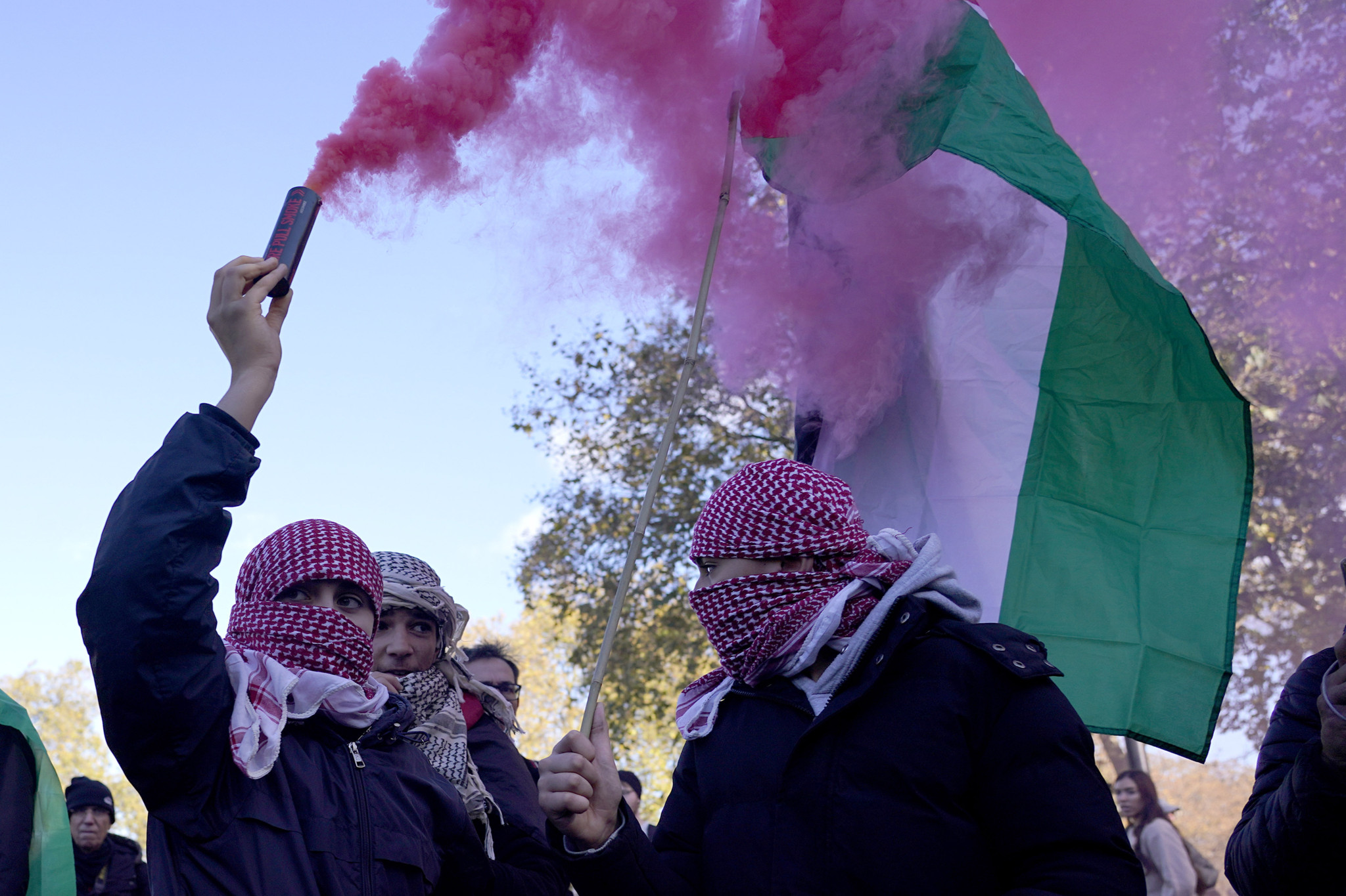 Protesters hold flares during a pro-Palestinian protest in London, Saturday, Nov. 11, 2023. London police have stepped up efforts to ensure a pro-Palestinian march on Saturday remains peaceful following a week of political sparring over whether the demonstration should go ahead on the weekend Britain honors its war dead.(AP Photo/Alberto Pezzali)