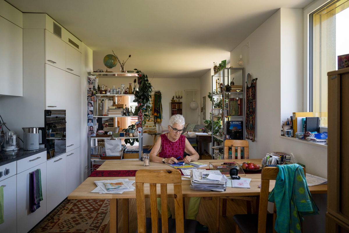 Une dame assise à la table dans son appartement.