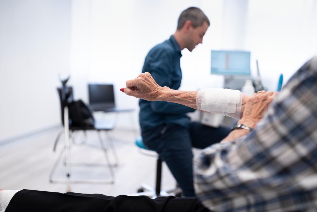 Un médecin généraliste soigne le bras d’un patient à l’Aerzthaus Seebach à Zurich, le 19 août 2019.