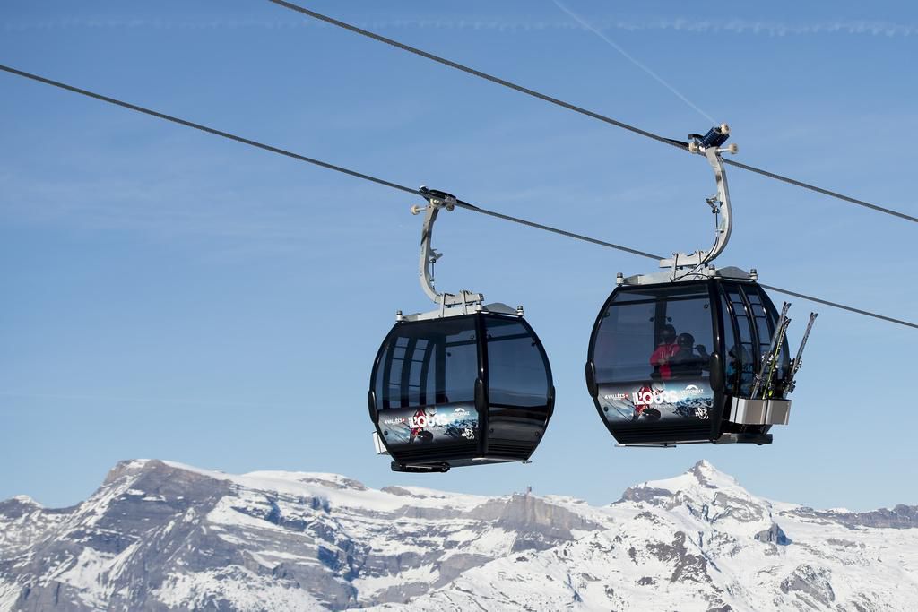 Cabine de la nouvelle télécabine 10 places sur la piste de l’Ours aux 4 Vallées, circulant face aux montagnes enneigées à Veysonnaz.