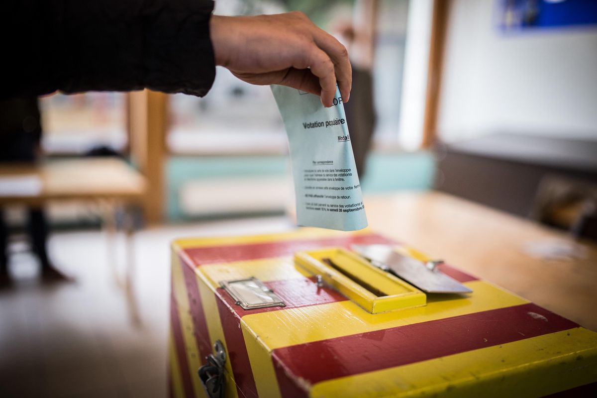 Enveloppe de matériel de vote insérée dans une boîte aux lettres.