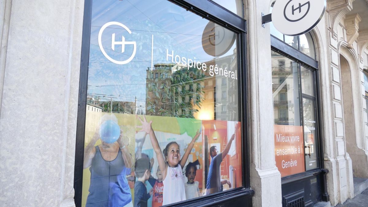 Façade de l’Hospice général avec une affiche colorée représentant des enfants joyeux.