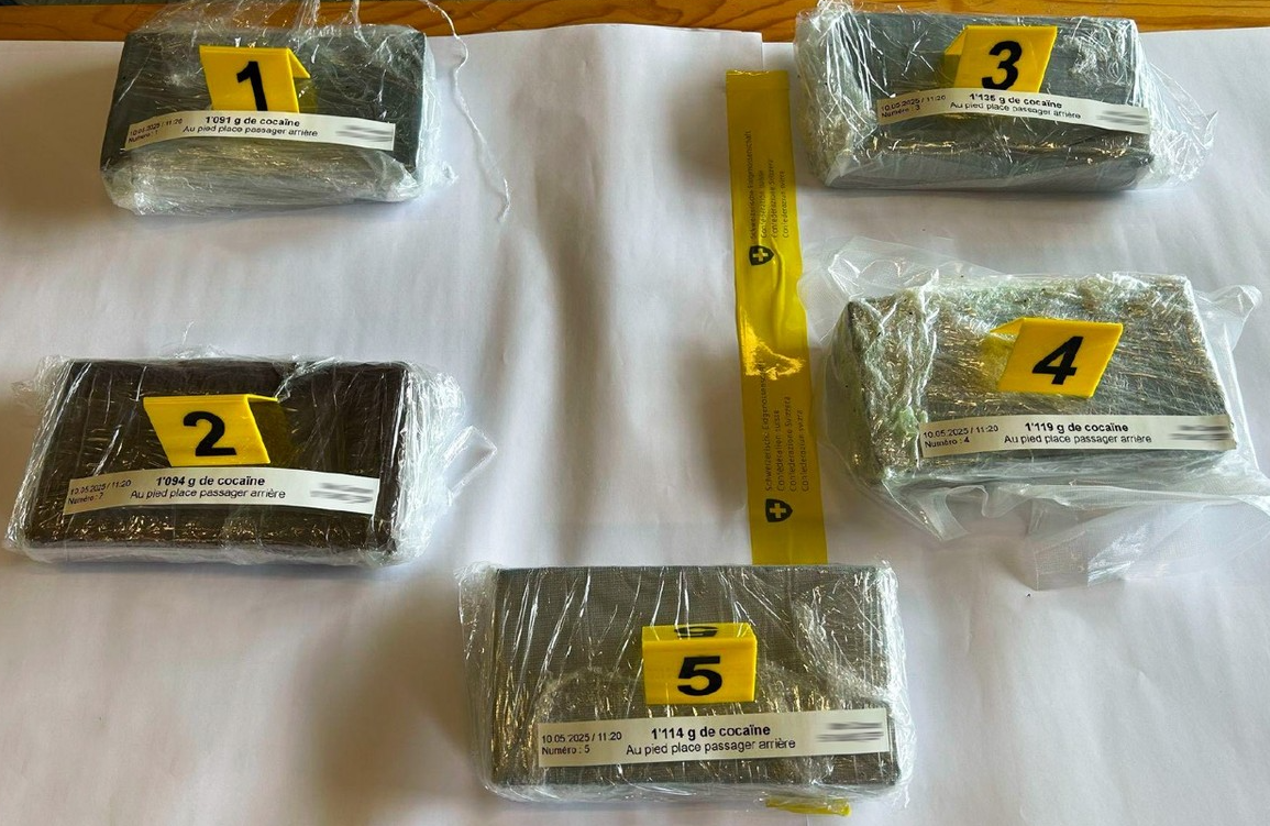 Cinq paquets de drogue emballés dans du plastique transparent, chacun avec un numéro d’étiquette de 1 à 5, sur une surface blanche.