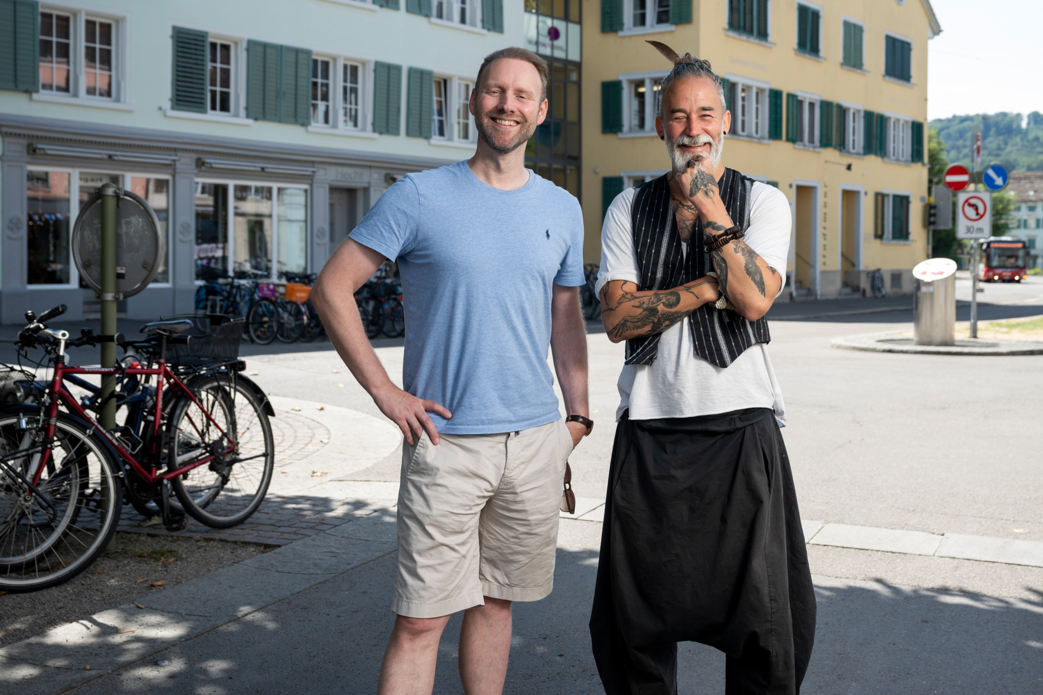 Renato Welter (blaues Shirt) und Oli Rust (grauer Bart) stehen lächelnd auf einem Platz. Welter gründet eine Männer-Selbsthilfegruppe.