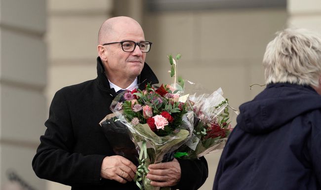 (FILES) In this file photo taken on October 14, 2021 Norway's Minister of Defense Odd Roger Enoksen (Centre Party) holds a bouquet of flowers as he poses on Slottsplassen palace square in front of the Royal Palace in Oslo, after he became member of the new government. - Norway's government announced on April 9, 2022 that defence minister Odd Roger Enoksen was resigning following revelations that he had a years-long affair with a much younger woman. (Photo by Heiko Junge / NTB / AFP) / Norway OUT