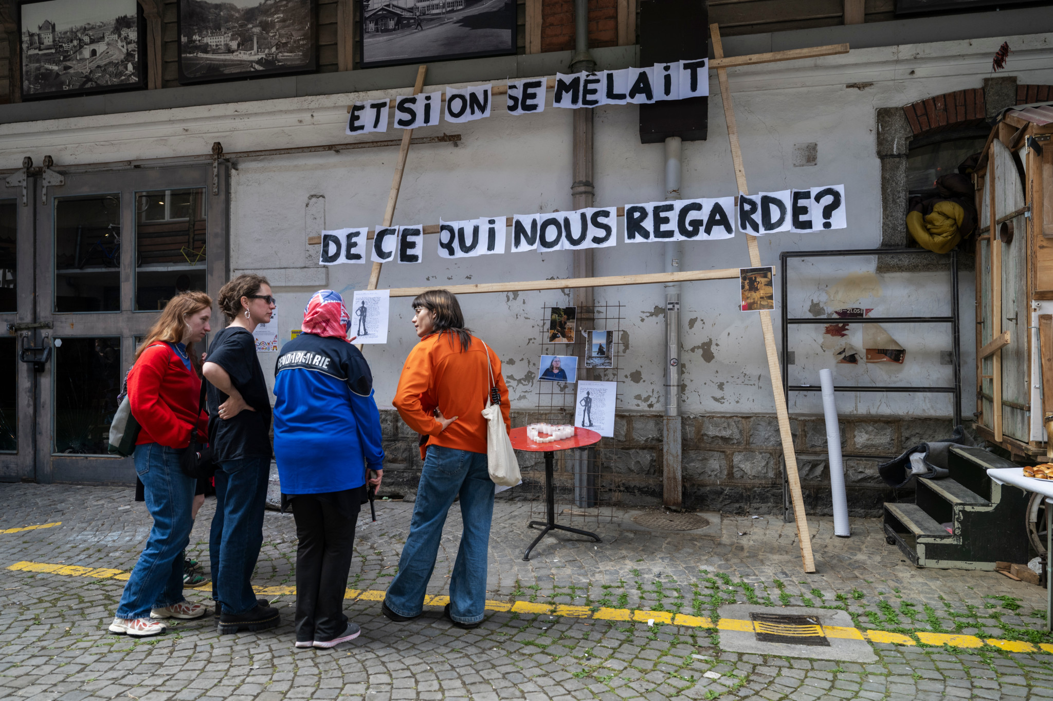 Quatre femmes sans-abri devant une banderole «Et si on se mêlait de ce qui nous regarde?» au Vallon à Lausanne, lors d’une rencontre internationale.
