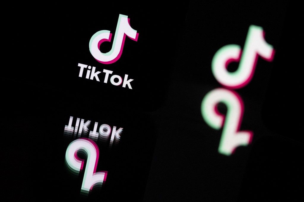 (FILES) This photograph taken in Mulhouse, eastern France on October 19, 2023, shows the logo of the social media video sharing app Tik Tok reflected in mirrors. British telecommunications regulator Ofcom said on July 24, 2024, it had handed video sharing platform TikTok a £1.9 million ($2.4 million) fine for failing to timely make available safety data. (Photo by SEBASTIEN BOZON / AFP)