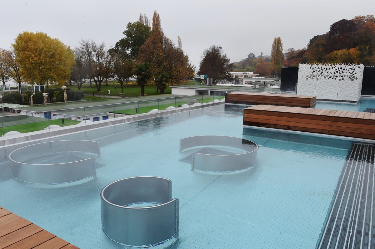 Vue du chantier de Bain Bleu, Hammam-SPA à Cologny, Genève, montrant des bains extérieurs avec des sections circulaires dans l'eau, quelques jours avant l'ouverture des installations.