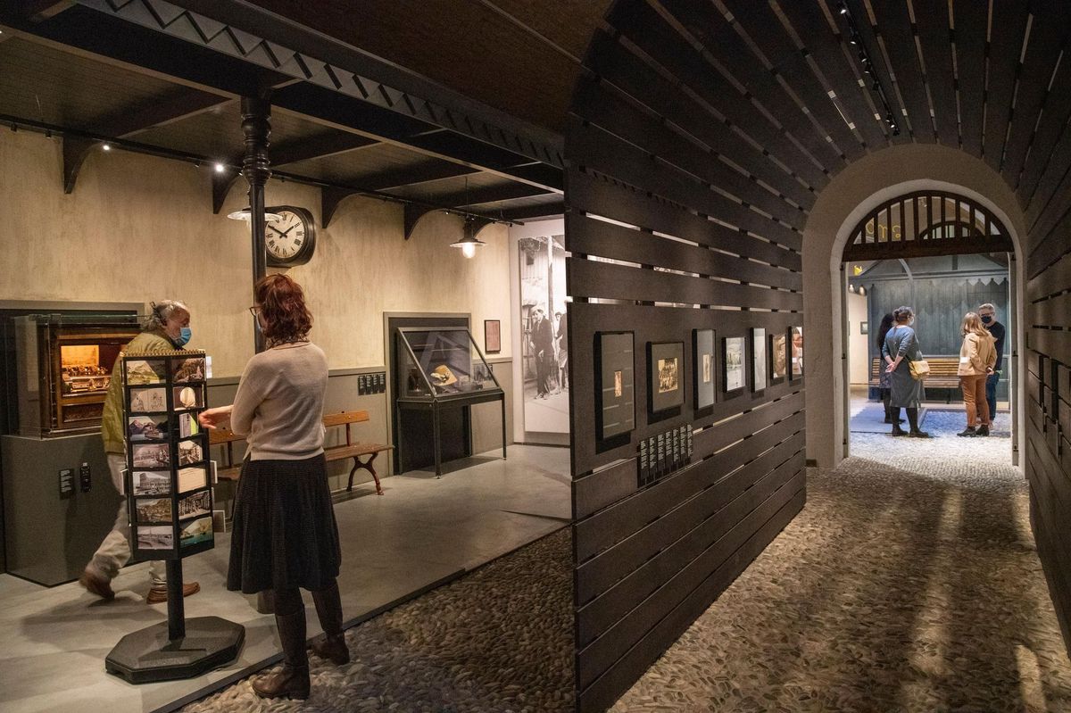Un tunnel, et un quai de gare avec son automate à musique, son horloge et son tourniquet de cartes postales font partie de la scénographie de la nouvelle exposition du Musée National Suisse de Prangins.

