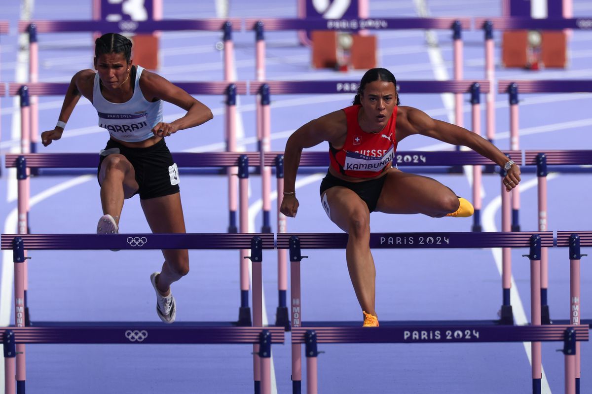 PARIS, FRANCE - AUGUST 07:  Jyothi Yarraji of Team India and Ditaji Kambundji of Team Switzerland compete during the Women's 100m Hurdles Round 1 on day twelve of the Olympic Games Paris 2024 at Stade de France on August 07, 2024 in Paris, France. (Photo by Al Bello/Getty Images)