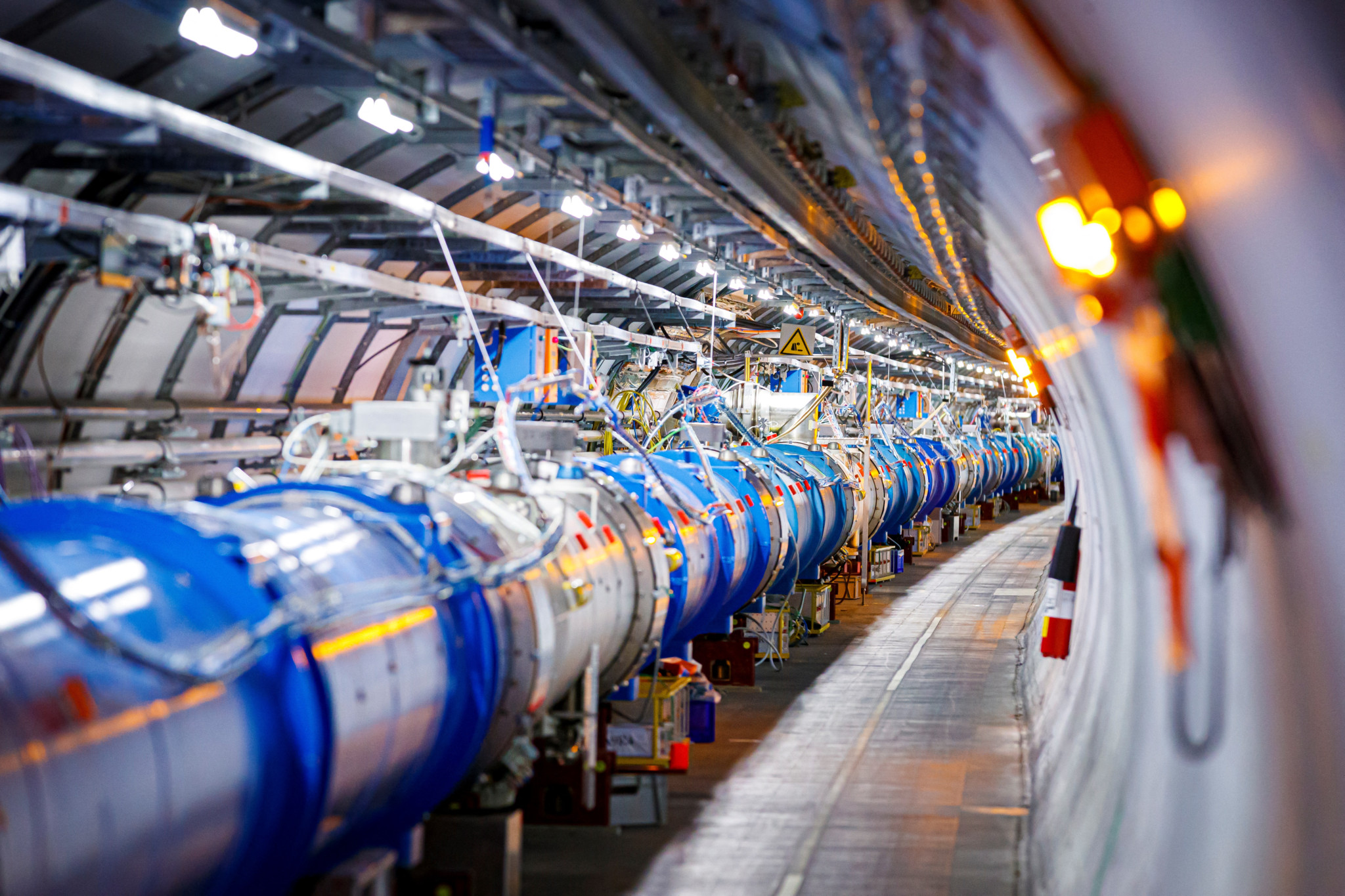 Tunnel du Grand collisionneur de hadrons (LHC) du CERN à Echenevex, avec ses aimants dipolaires bleus s’étendant à perte de vue.