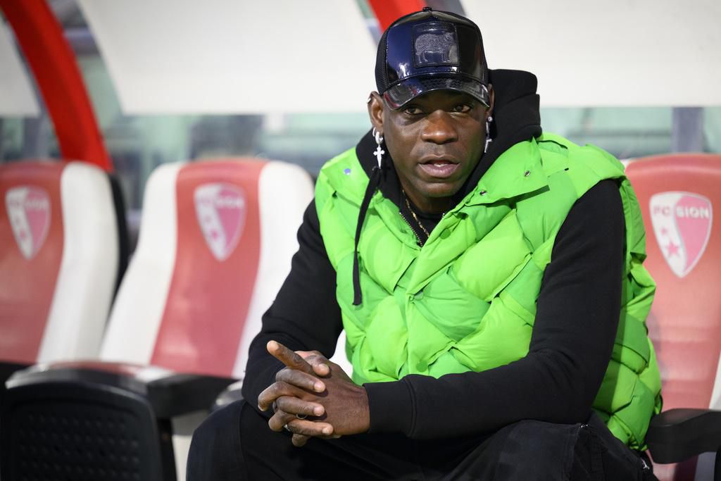 Mario Balotelli assis sur le banc, portant un gilet vert, lors du match entre FC Sion et Servette FC, 8 avril 2023, stade de Tourbillon.