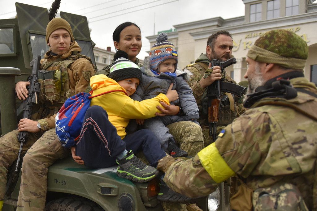 epa10308511 A Ukrainian servicewoman hugs children on the central square of Kherson, Ukraine, 16 November 2022. The Russian army, after retreat from Kherson, destroyed critical infrastructure, with elecricity and water scarce in the city. Ukrainian troops entered Kherson on 11 November after Russian troops had withdrawn from the city. Kherson was captured in the early stage of the conflict, shortly after Russian troops had entered Ukraine in February 2022. EPA/OLEG PETRASYUK
