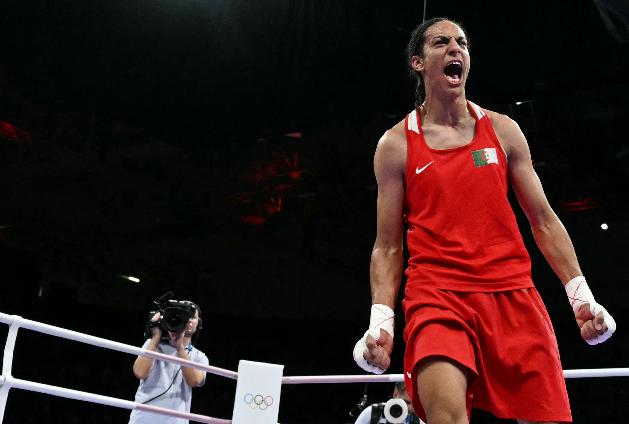TOPSHOT - Algeria's Imane Khelif celebrates her victory over Hungary's Anna Luca Hamori in the women's 66kg quarter-final boxing match during the Paris 2024 Olympic Games at the North Paris Arena, in Villepinte on August 3, 2024. (Photo by MOHD RASFAN / AFP)