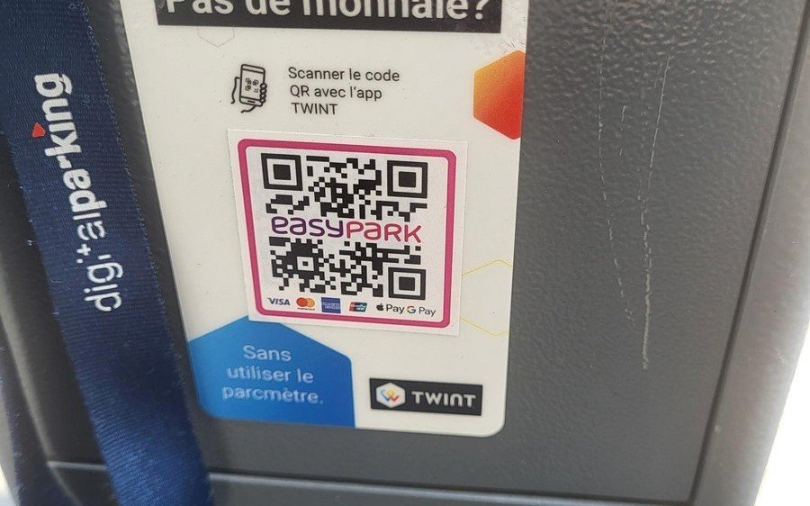 Un panneau QR code pour l’application EasyPark sur un parcmètre avec options de paiement Visa, PayPal et G Pay.