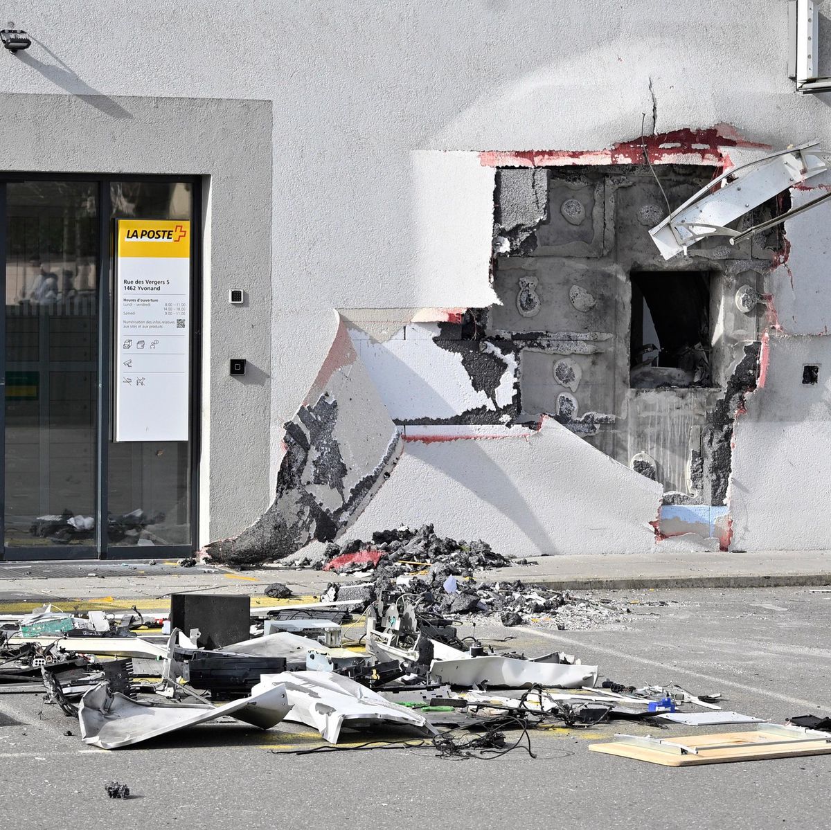 Façade endommagée d’un bâtiment après une tentative de braquage à l’explosif d’un bancomat de la Poste à Yvonand, avec des débris éparpillés au sol. Photo prise par Patrick Martin pour 24Heures.