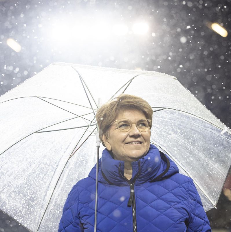 Viola Amherd, conseillère fédérale suisse, sous un parapluie transparent sous la neige lors du match Suisse-Suède au stade Swissporarena.