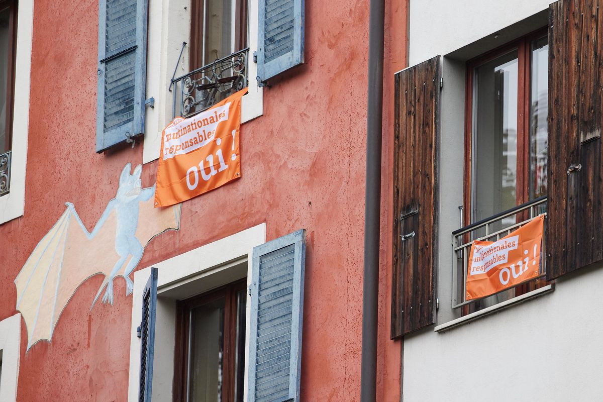Drapeaux en faveur de l’initiative pour des entreprises responsables accrochés aux fenêtres à Genève, octobre 2020.