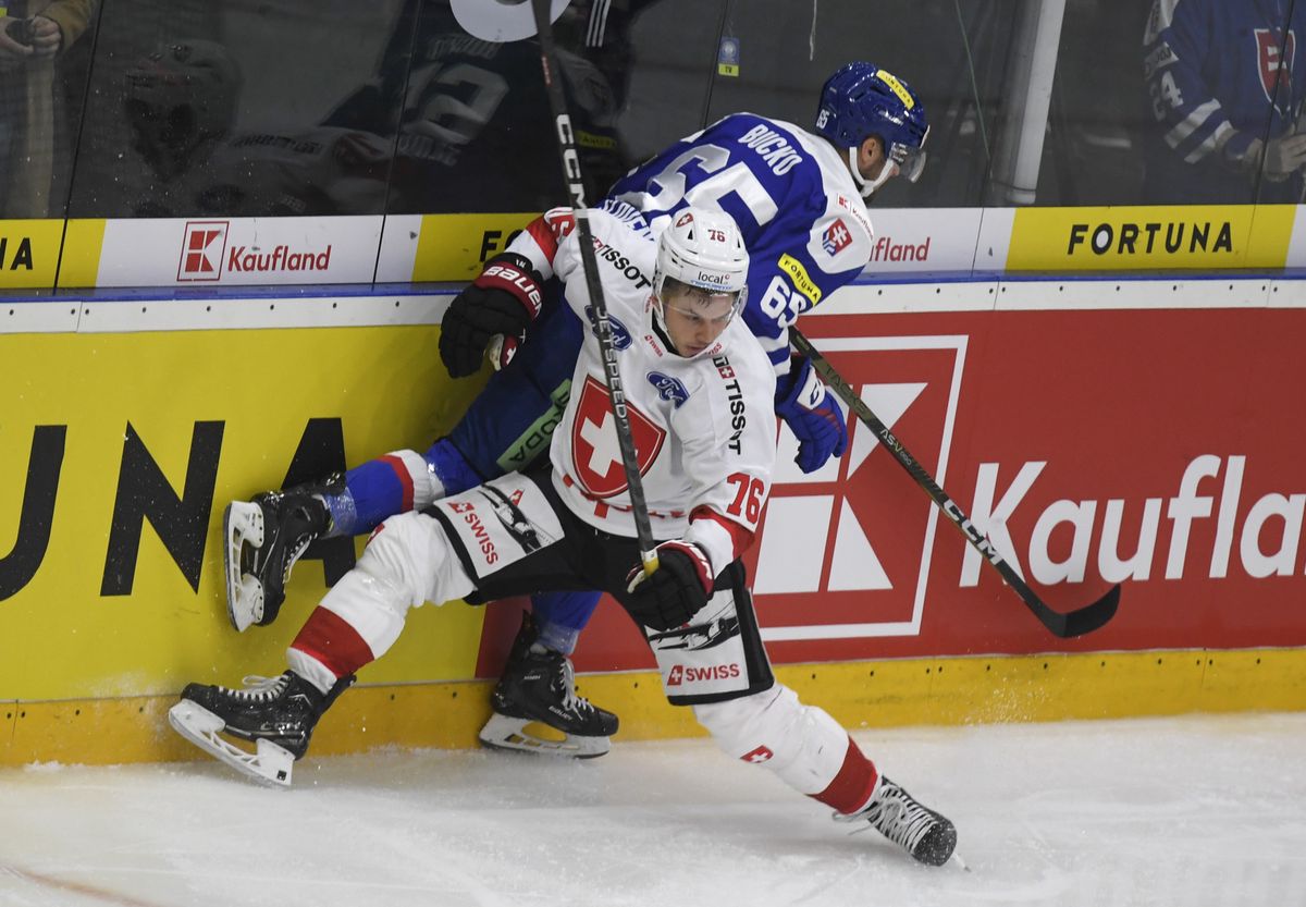 Tino Kessler of Switzerland, left, and Martin Bucko of Slovakia, right, fight for the puck during the friendly ice hockey match between Slovakia and Switzerland in Humenne, Slovakia, Thursday, April 11, 2024. (Ivan Frantisek/TASR via AP)