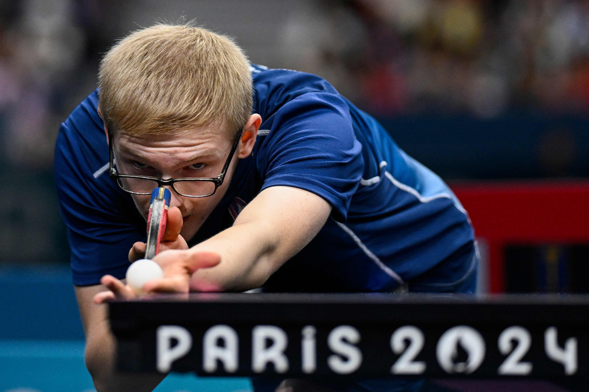 France's Felix Lebrun serves the ball during his men's table tennis singles bronze medal match against Brazil's Hugo Calderano at the Paris 2024 Olympic Games at the South Paris Arena in Paris on August 4, 2024. (Photo by WANG Zhao / AFP)