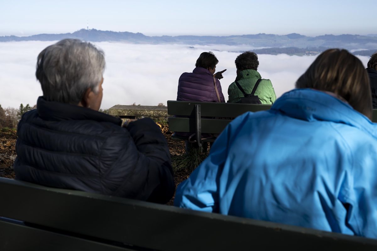 Personnes profitant du soleil au-dessus d'une mer de brouillard lors d'une belle journée d'automne au Gurten, près de Berne.