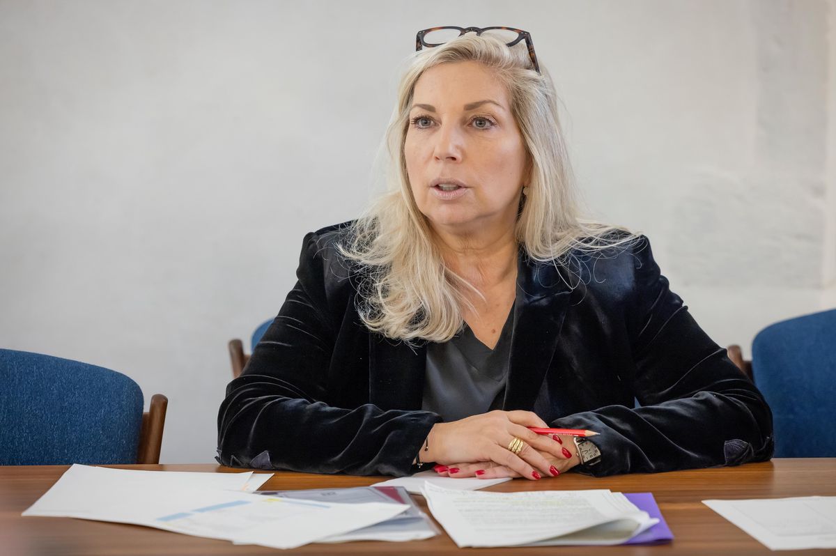 Nathalie Fontanet, Conseillère d’État, lors d’un point presse à l’Hôtel de Ville de Genève, entourée de documents sur une table.