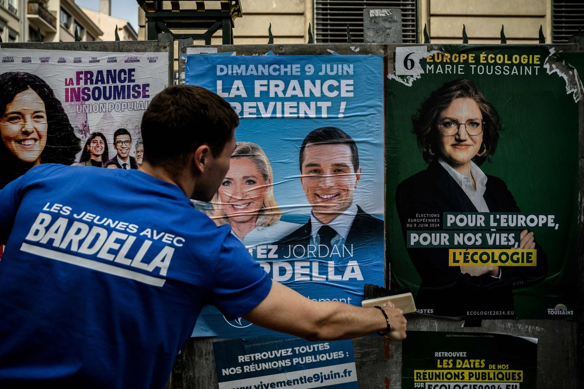 A France's far-right Rassemblement National (RN) party volunteer pastes a campaign poster of party President and lead European Parliament election candidate Jordan Bardella in Lyon on May 6, 2024, ahead of the June 9 European Parliament election. (Photo by JEFF PACHOUD / AFP)