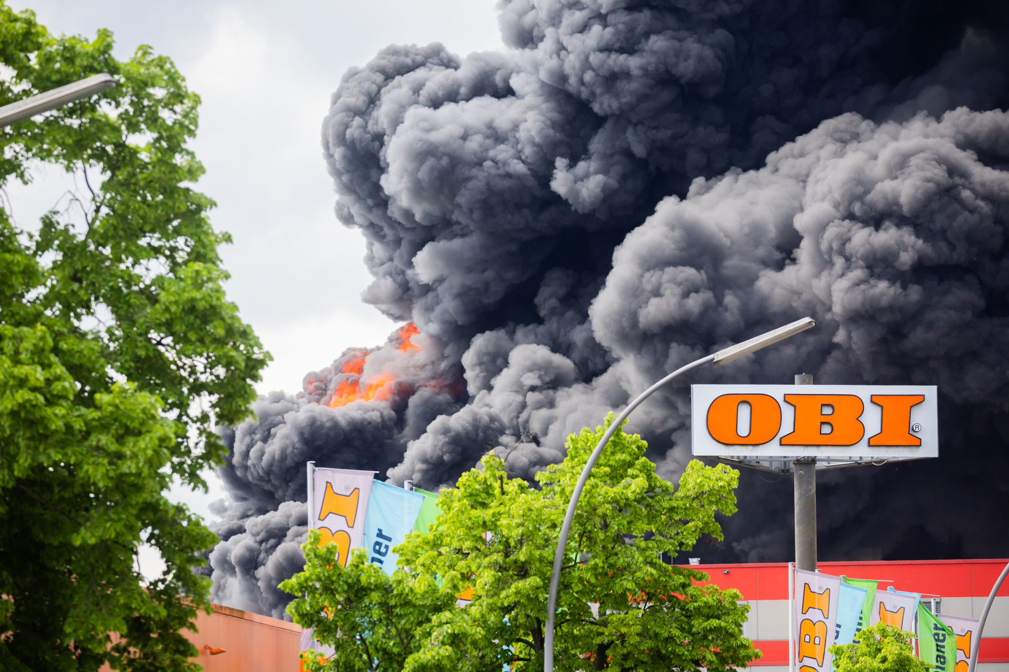 03.05.2024, Berlin: Flammen und dichter Qualm sind bei einem Brand in Berlin-Lichterfelde in der Rauchsäule zu sehen. In einem Betrieb in Berlin-Lichterfelde ist am Freitag ein Feuer ausgebrochen. Ein Technikraum im 1. Obergeschoss eines Fabrikgebäudes brenne «in voller Ausdehnung», wie ein Feuerwehrsprecher am Vormittag sagte. In der Firma für Metalltechnik seien Chemikalien gelagert. Vorsorglich habe die Feuerwehr eine Gefahreninformation rausgegeben. Foto: Christoph Soeder/dpa +++ dpa-Bildfunk +++ (KEYSTONE/DPA/Christoph Soeder)
