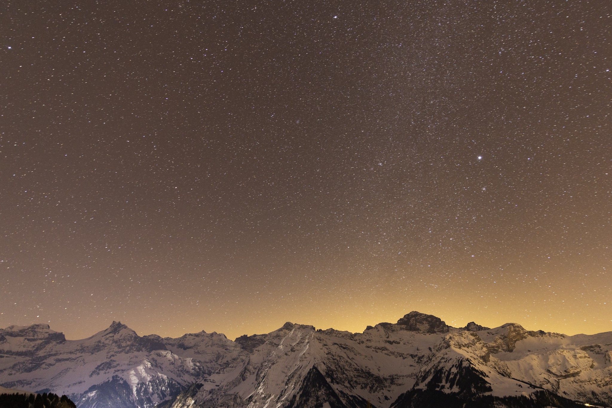Goldene Stunde: Das Nachthimmelsleuchten erhellt Kämme und Gipfel vor der Terrasse des Skihauses Edelweiss.