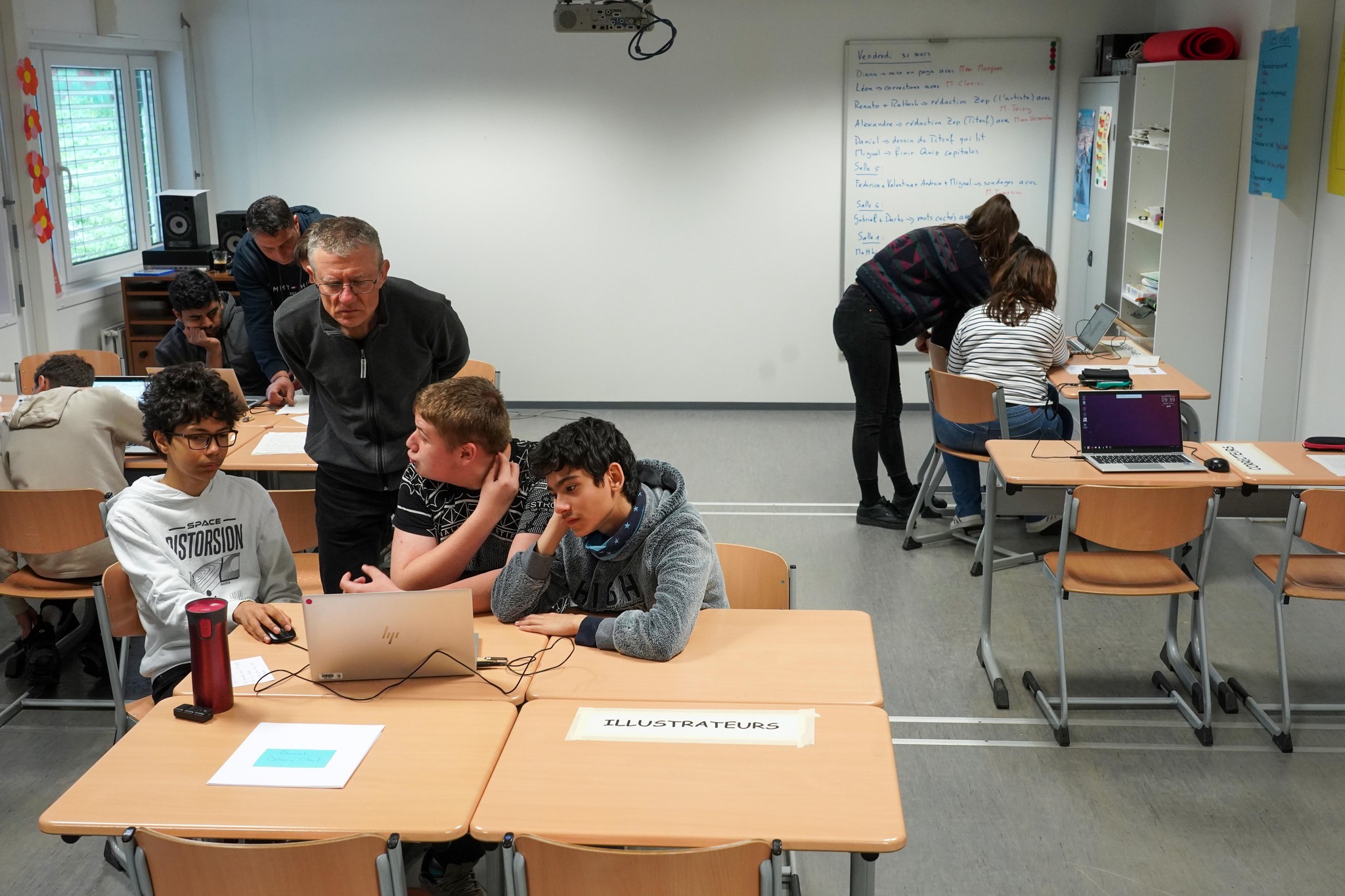 Les illustrateurs Léon, Miguel et Gabriel, accompagné par Raphaël, enseignant.