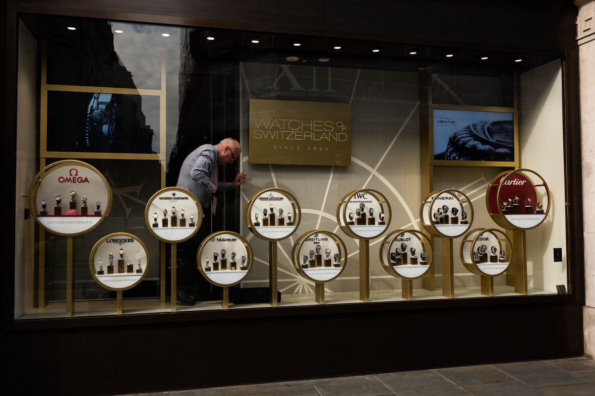 An employee works on the display in the window of a Watches of Switzerland Group Plc store on Regent Street in London, UK, on Wednesday, Aug. 30, 2023. One of Watches of Switzerland Group Plc's biggest investors cut its stake in the UK-listed timepiece retailer less than 24 hours after Rolex SA decided to buy a rival, Bucherer AG. Photographer: Jose Sarmento Matos/Bloomberg via Getty Images