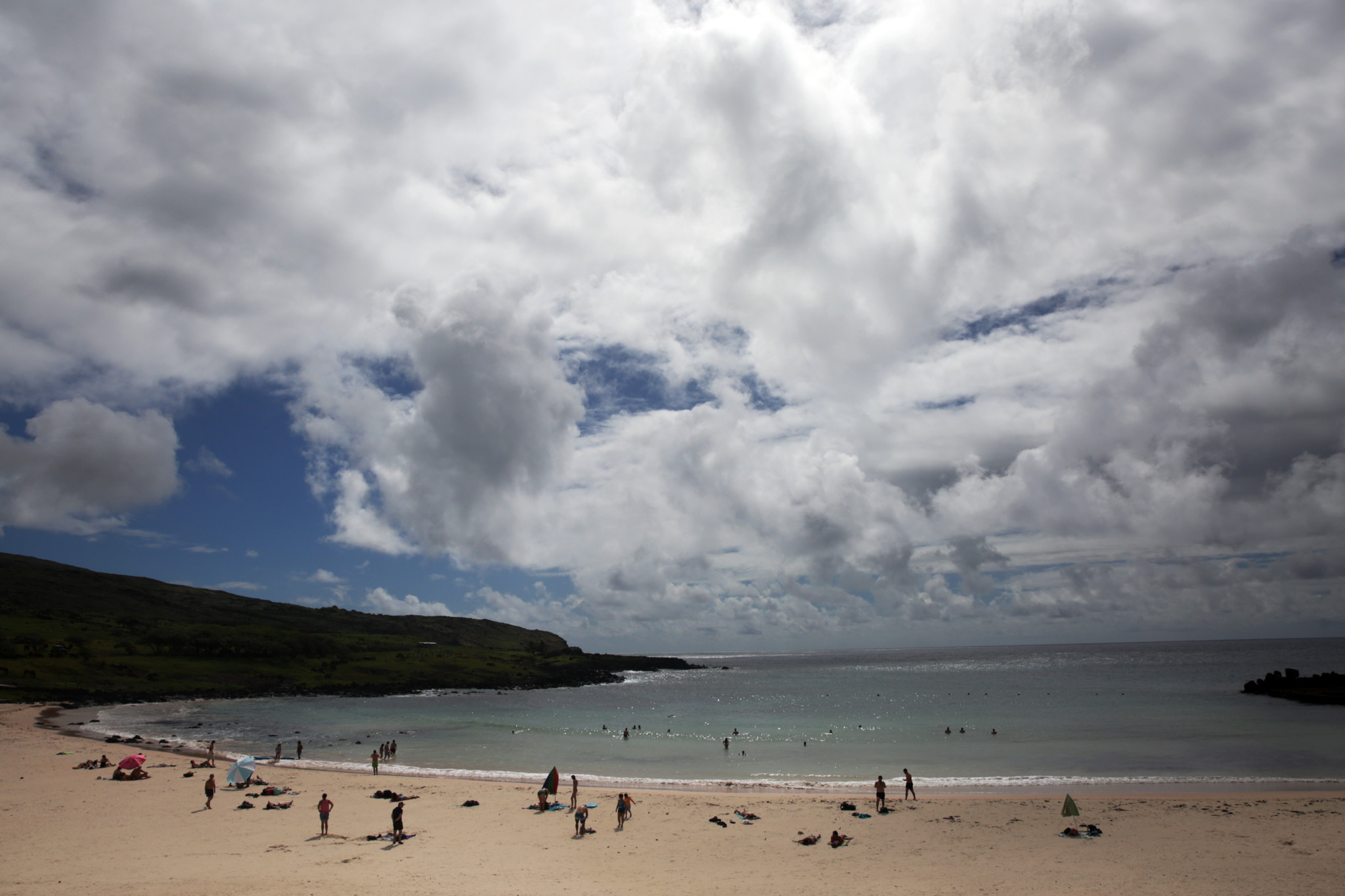 Strand von Anakena auf der Osterinsel, Chile, mit Badegästen unter bewölktem Himmel, Schauplatz des Gipfels der Pazifikführer 2024 über Ozeanschutz.