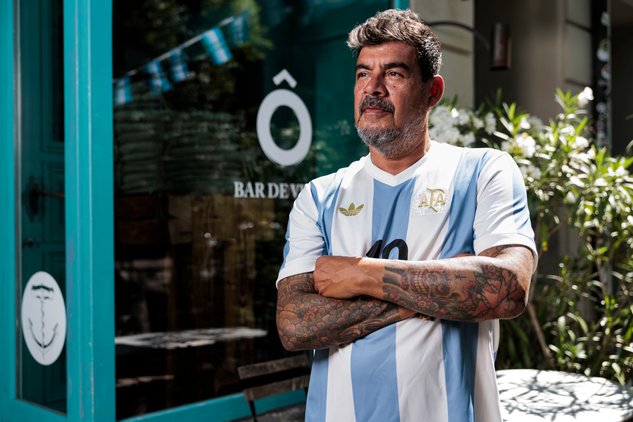 Anibal Acosta mit verschränkten Armen im Argentinien-Trikot von Lionel Messi vor seiner Bar de Vinos im Berner Breitenrain. Anibal Acosta mit verschränkten Armen im Argentinien-Trikot von Lionel Messi vor seiner Bar de Vinos im Berner Breitenrain.