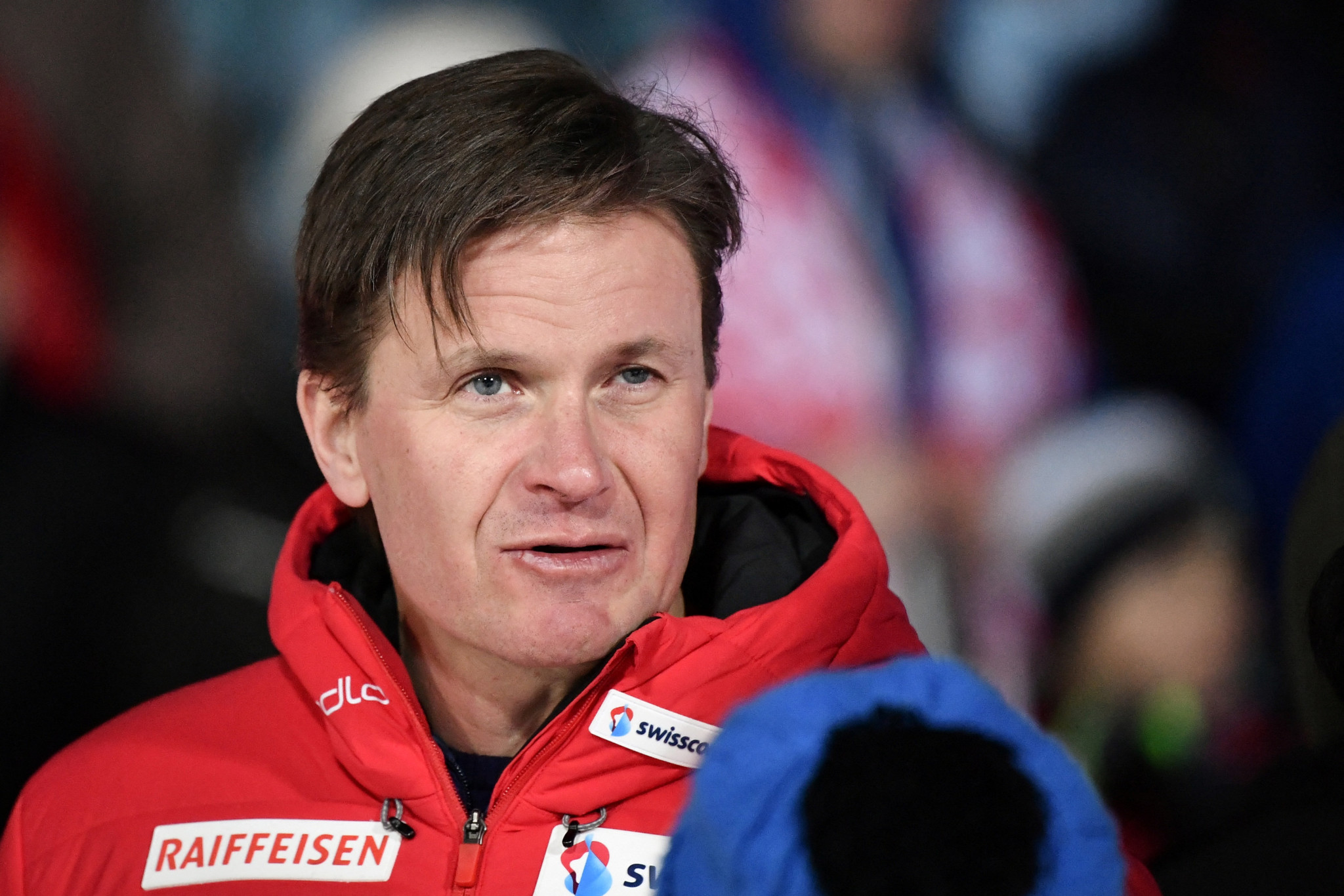 Swiss-Ski-Präsident Urs Lehmann in roter Jacke mit Raiffeisen-Logo bei der Podiumszeremonie des FIS Skispringen Weltcups in Engelberg.