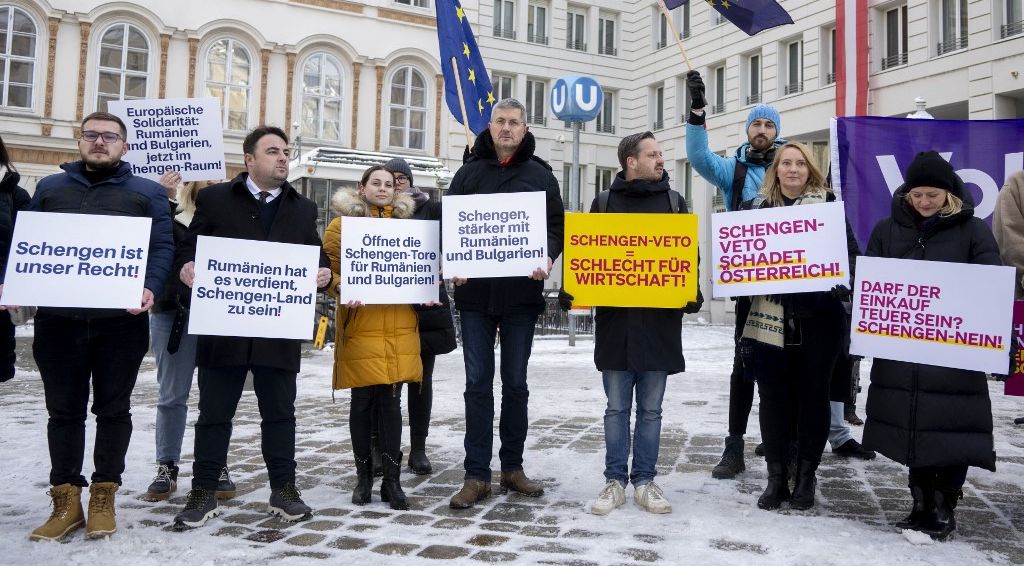 People hold placards reading (L-R): "Schengen is our right", "European solidarity: Romania and Bulgaria now in the Schengen zone", "Romania deserves being a Schengen country", "Open the doors of Schengen for Romania and Bulgaria!", "the Schengen-veto is bad for economy" during a protest of the liberal Neos party in front of the Austrian interior Ministry building in Vienna, Austria on December 4, 2023, on the eve of the EU Council of Interior Ministers in Brussels. (Photo by Joe Klamar / AFP)
