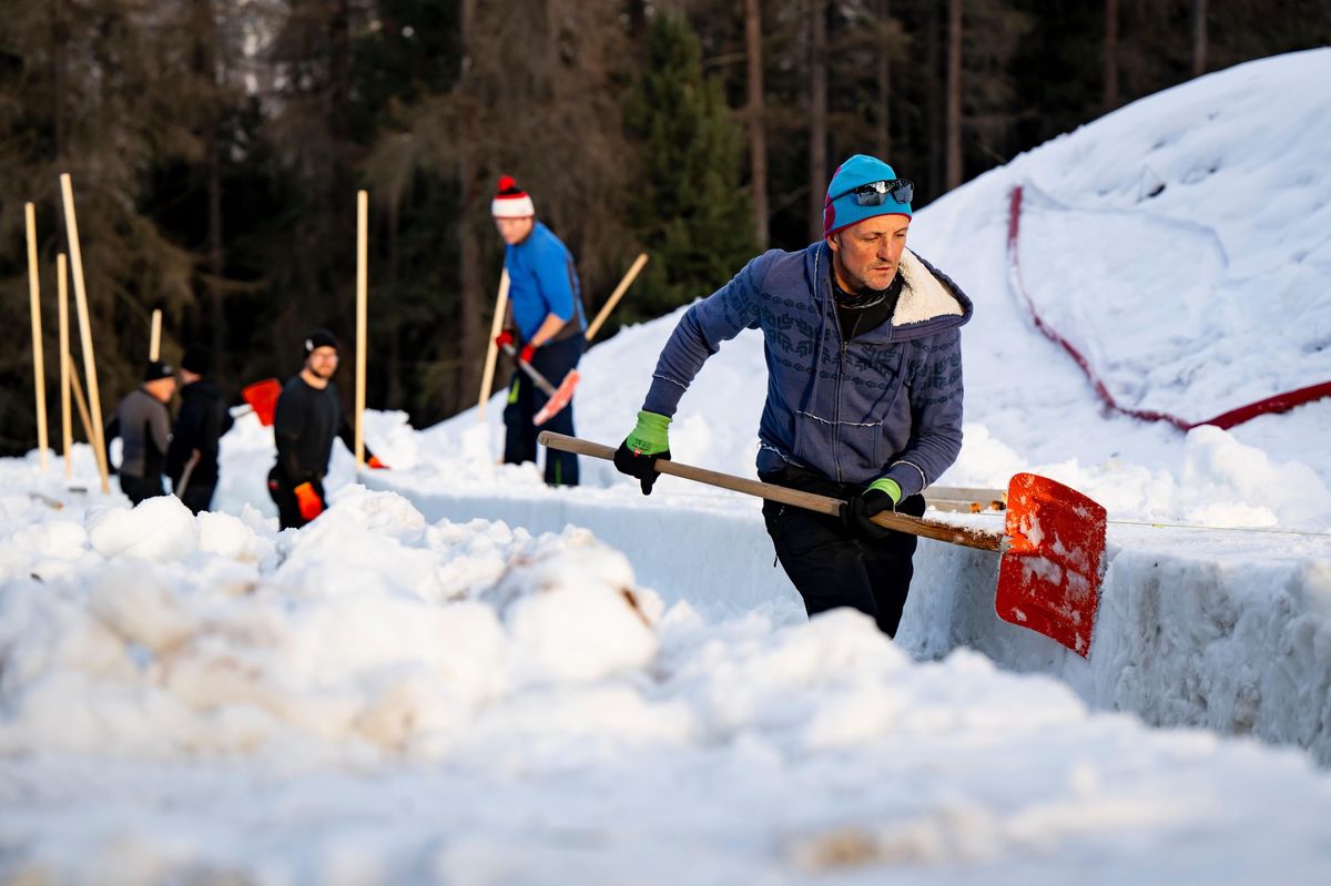 Ouvriers construisant la piste de bobsleigh Olympia à St. Moritz avec Paul Weihtaler au centre, neige et pelles visibles.