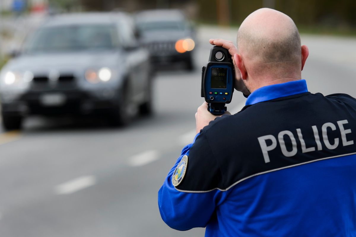 Un policier de la police cantonale vaudoise controle la vitesse d'une vehicule a l'aide d'un radar jumelle sur une route, mercredi 9 mars 2016, a Commugny dans le canton de Vaud. 