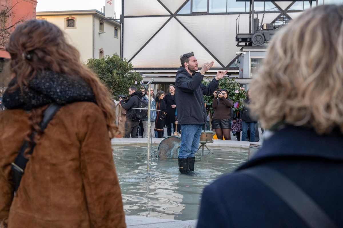 Flashmob au Flon à Lausanne, avec le chef de chœur Jérémie Zwahlen les pieds dans l’eau, lançant les Rencontres du 7ème Art.