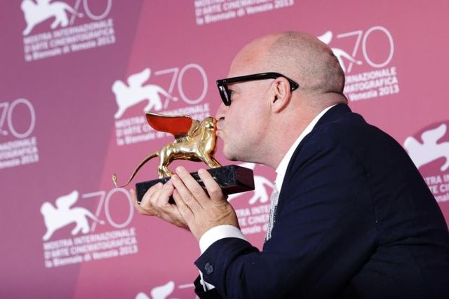 Gianfranco Rosi embrasse le Lion d'Or qu'il a reçu en 2013 pour son film Sacro Gra.